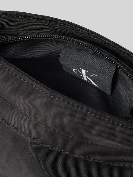 Produktfoto, schwarze Crossbody Bag mit Label-Stitching von CK Calvin Klein, Reißverschluss, textile Struktur, Detailaufnahme Innenansicht