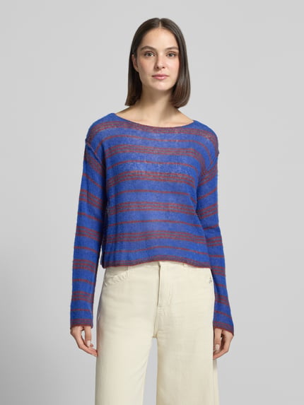 Frauenmodel trägt Relaxed Fit Strickpullover aus Lyocell-Mix Modell 'BODYROW' von American Vintage in Blau mit rotbraunen Streifen, transparenter Struktur, U-Boot-Ausschnitt, langärmligem Design und überschnittenen Schultern, Ganzkörperansicht von vorne.