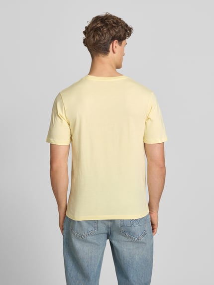 Männermodel trägt T-Shirt mit Label-Print Modell 'CASSIS' von Jack & Jones aus Reine Baumwolle, Regular-Fit, Rundhalsausschnitt, Rückenlänge 68 cm, sanftgelber Ton, glatte Struktur, Ganzkörperansicht Rückansicht.