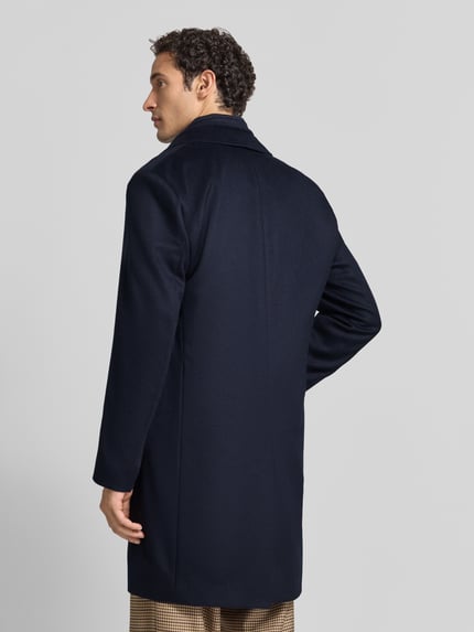 Männermodel trägt Mantel aus Wolle mit integriertem Stehkragen von BOSS BLACK, unifarben, Struktur, Reverskragen, Ganzkörperansicht Rückansicht.