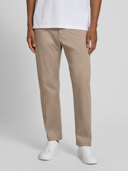 Männermodel trägt Straight Fit Stoffhose mit Eingrifftaschen Modell 'Ajend' von Drykorn, beige, leichte Struktur, Ganzkörperansicht von vorne. Elastischer Baumwoll-Mix, Knopf- und Reißverschluss, Bundweite 42 cm, Innenbeinlänge 74 cm bei Größe 32/32.