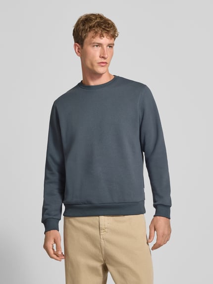 Männermodel trägt Regular Fit Sweatshirt mit Baumwoll-Anteil Modell 'Bradley' von JACK & JONES in Dunkelblau und Beige, Ganzkörperansicht von vorne. Herren Sweatshirt, Rundhalsausschnitt, Langarm, gerippte Abschlüsse, Logo-Label, Material-Mix, Rückenlänge 66 cm, Ärmellänge 64 cm.