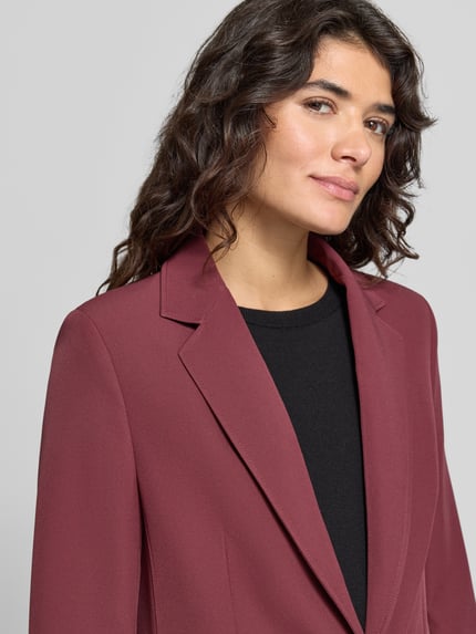 Vrouwenmodel draagt Regular Fit Longblazer met schoudervullingen van BOSS Orange, kleur: effen, geweven motief binnenkant, detailopname bovenlichaam.