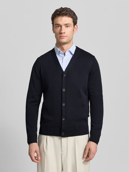 Männermodel trägt Cardigan aus zuivere scheerwol met V-hals, regular fit, knoopsluiting van MAERZ Muenchen, ganzkörperansicht van voren. Ruglengte 68 cm, mouwlengte 64 cm bij maat 50.