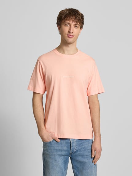 Männermodel trägt T-Shirt mit Label-Stitching Modell 'NORREBRO' von Jack & Jones in Hellrosa, reine Baumwolle, Ganzkörperansicht von vorne.