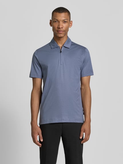 Männermodel trägt Regular Fit Poloshirt aus Lyocell-Baumwoll-Mix Modell 'H-PARAS 50' von BOSS, unifarben, Kurzarm, Ganzkörperansicht von vorne.