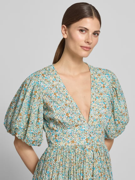 Vrouwenmodel draagt 'Cocktailkleid mit V-Ausschnitt und Puffärmeln' van LACE & BEADS in lichtblauw met bloemmotief, zuivere katoen, a-lijn, v-hals, pofmouwen, midilengte, borstwijdte 35 cm, ruglengte 124 cm, mouwlengte 30 cm; close-up bovenlichaam vooraanzicht.