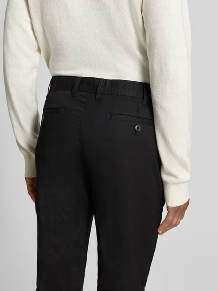 Männermodel trägt Slim Fit Stoffhose mit Viskose-Anteil von MCNEAL in Schwarz, Gesäßtaschen, Rückansicht, Nahaufnahme Oberkörper.