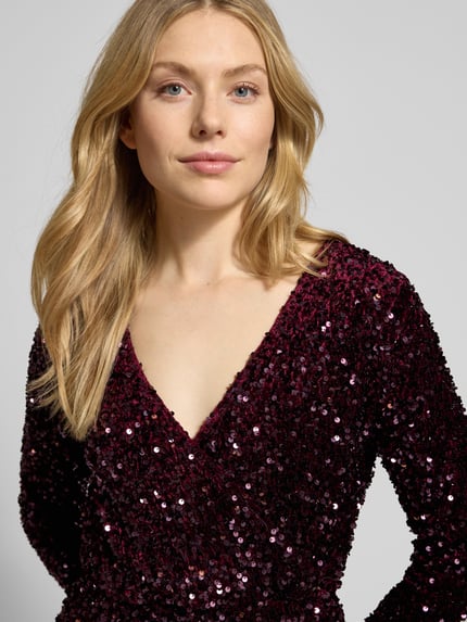 Frauenmodel trägt Midikleid mit V-Ausschnitt Modell 'FAITH' von Vila in Bordeaux mit Pailletten, tailliert, langärmelig, Nahaufnahme Oberkörper.