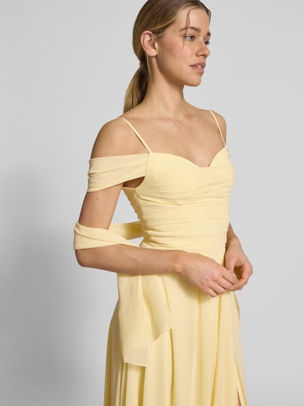 Frauenmodel trägt Maxikleid im Off-Shoulder-Look mit Gehschlitz von Mascara in zartem Gelb, A-Linie, Drapierungen, Nahaufnahme Oberkörper. Rückenlänge bei Größe 36: 128 cm, Brustweite bei Größe 36: 33 cm.
