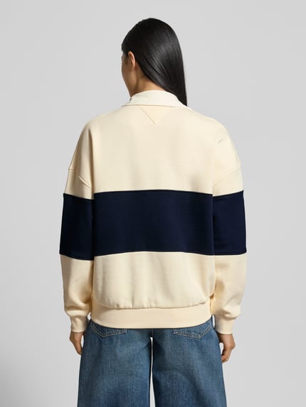 Frauenmodel trägt Relaxed Fit Sweatshirt aus Baumwoll-Mix von Tommy Hilfiger in Two-Tone-Optik mit Logo-Stitching, Polokragen, langarm, gerippten Abschlüssen, Sweat-Material und Baumwoll-Mix, Ganzkörperansicht Rückansicht.