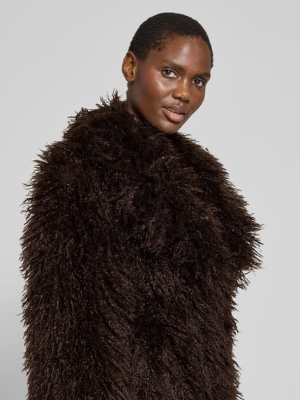 Frauenmodel trägt Regular Fit Jacke aus Kunstfell mit Reverskragen von Smith and Soul in dunkelbraun, flauschige Textur, Nahaufnahme Oberkörper, Rückenlänge 66 cm, Schulterbreite 49 cm, Brustweite 50 cm, Ärmellänge 62 cm.