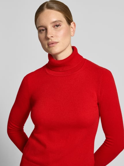 Frauenmodel trägt Regular Fit Rollkragenpullover aus reinem Kaschmir von Christian Berg Woman in Rot, gerippter Kragen, Nahaufnahme Oberkörper.