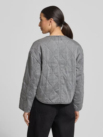 Frauenmodel trägt Regular Fit Jacke aus reinem Lyocell Modell 'Alina' von CARS JEANS in Stepp-Optik, grauer Farbton, Rundhalsausschnitt, sichtbare Stepp-Nähte, lange Ärmel, Rückenlänge bei Größe S: 58 cm, Schulterbreite 49 cm, Brustweite 53 cm, Ärmellänge 53 cm, Ganzkörperansicht Rückansicht.