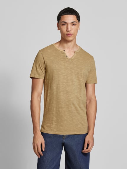 Mannenmodel draagt T-shirt uit katoen model 'SPLIT' van Jack & Jones in recht model met V-hals en knoopsluiting, ruglengte maat M 67 cm, vooraanzicht busteshot.