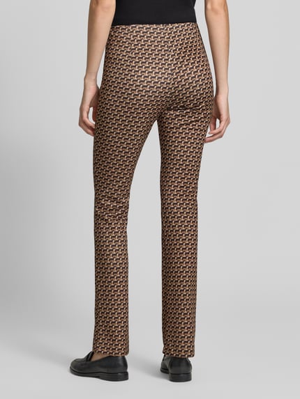 Männermodel trägt Flared Cut Hose im Allover-Look mit elastischem Bund von Marc Cain, Mieszanka materiałów z dodatkiem streczu, wzór na całej powierzchni w odcieniach brązu i czerni, Szerokość w rozmiarze 36: 37 cm, długość wewnętrzna nogawki w rozmiarze 36: 82 cm, Ganzkörperansicht Rückansicht