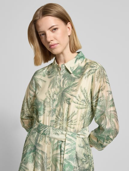 Frauenmodel trägt Figurumschmeichelndes Freizeitkleid aus Lyocell-Mix von s.Oliver BLACK LABEL in Floralem-Allover-Muster, Knopfleiste, Taillengürtel, V-Ausschnitt, 3/4-Arm, Popeline, Viskose-Mix, sanfte Grün- und Cremetöne; Nahaufnahme Oberkörper.