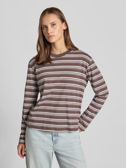 Vrouwenmodel draagt Relaxed Fit shirt met lange mouwen uit puur katoen van JJXX, ronde hals, bruin-witte strepen, ruglengte maat S: 55 cm, voorkant volledige lichaamsaanzicht.
