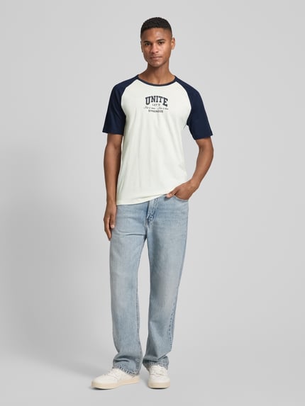Männermodel trägt Regular Fit T-Shirt aus reiner Baumwolle von s.Oliver RED LABEL, two tone Optik, kurzarm, Rundhals, Statement Print, Ganzkörperansicht von vorne.