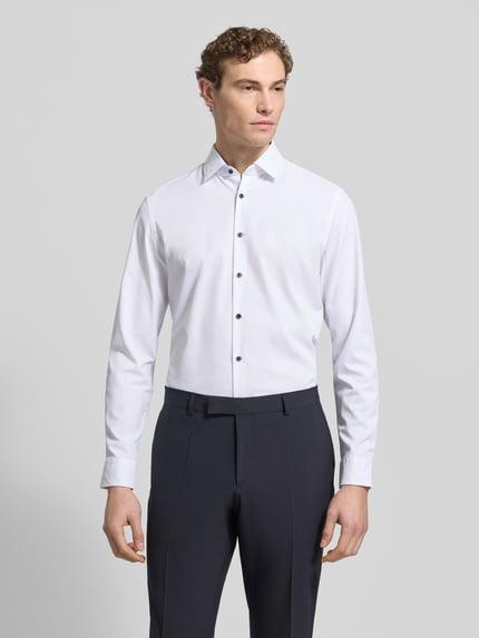 Männermodel trägt Slim Fit Business-Hemd mit Knopfleiste von Jake*s, weiß, Material-Mix mit Stretch-Anteil, Kentkragen, Ganzkörperansicht von vorne. Rückenlänge bei Größe 39/40: 75 cm, Schulterbreite: 45 cm, Ärmellänge: 66 cm.