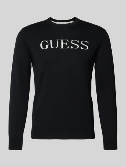 Produktfoto, schwarzer Regular Fit Pullover in Strick-Optik Modell 'Kane' von Guess aus reiner Baumwolle mit weißem Logo-Stitching auf der Brust.