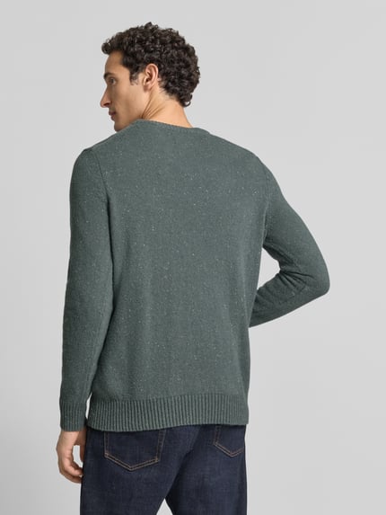 Männermodel trägt Pullover mit Tweed-Struktur von MARC O'POLO in melierter Strickoptik, gerippte Abschlüsse, Ganzkörperansicht Rückansicht.
