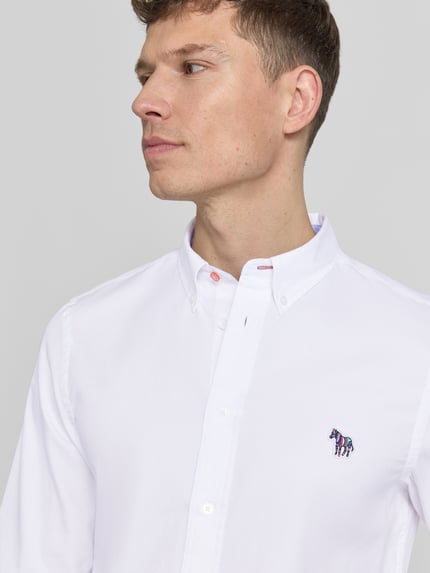 Männermodel trägt Tailored Fit Freizeithemd mit Button-Down-Kragen von PAUL SMITH aus reiner Baumwolle mit Stitching, Nahaufnahme Oberkörper.