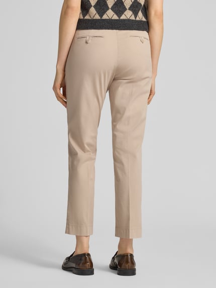 Vrouwenmodel draagt Hose mit Gesäßtaschen Modell 'KIANA' van Cambio, beige katoen-elastaanmix, verkorte fit, detail achteraan, Ganzkörperansicht Rückansicht.