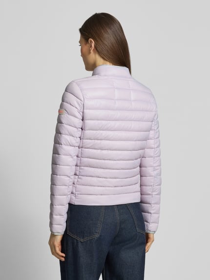 Frauenmodel trägt lilafarbene Steppjacke mit Reißverschlusstaschen Modell 'SISTER JUDY' von Frieda & Freddies, Rückenansicht, Ganzkörperansicht.