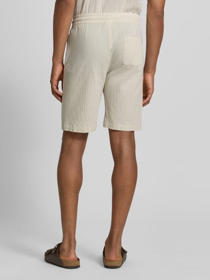 Männermodel trägt Shorts mit elastischem Bund und Strukturmuster von Lindbergh aus Baumwoll-Mix mit Stretch-Anteil, Loose-Fit, Ganzkörperansicht Rückansicht.