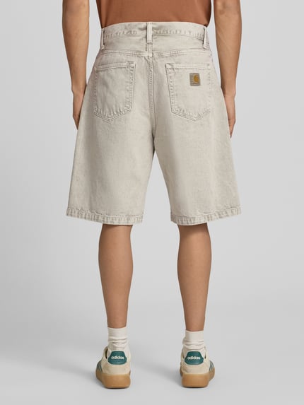 Männermodel trägt Jeansshorts mit Eingrifftaschen Modell 'Smithfield' von Carhartt Work In Progress, Reine Baumwolle, Relaxed-Fit, Ganzkörperansicht Rückansicht.