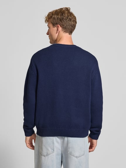 Männermodel trägt Regular Fit Strickpullover aus Baumwoll-Mix von REVIEW in Dunkelblau mit gerippten Abschlüssen, Ganzkörperansicht Rückansicht.