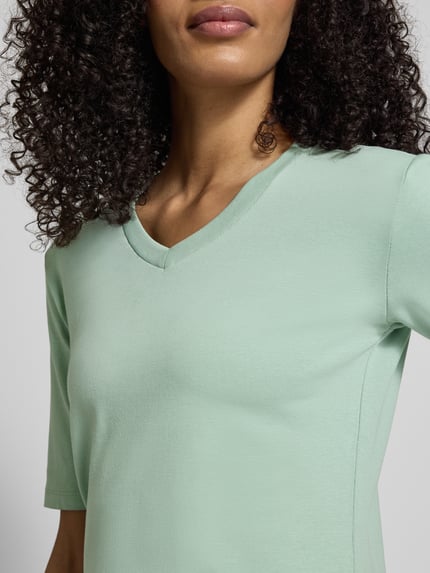 Frauenmodel trägt T-Shirt mit V-Ausschnitt von Christian Berg Woman in Mintgrün, Baumwoll-Elasthan-Mix, Nahaufnahme Oberkörper.