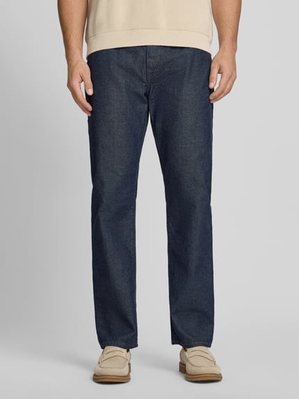 Męski model nosi Relaxed Straight Fit Jeans mit Eingrifftaschen od GAP, ciemnoniebieska bawełna, wpuszczane kieszenie, zapięcie na guzik i zamek błyskawiczny, szerokość w rozmiarze 32/32: 44 cm, długość wewnętrzna nogawki: 78 cm, zdjęcie całej sylwetki z przodu.