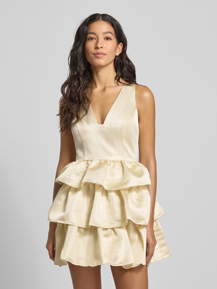 Frauenmodel trägt Cocktailkleid aus Satin im Stufen-Look von Adrianna Papell, cremefarben, A-Linie, V-Ausschnitt, Minikleid, Ganzkörperansicht von vorne.