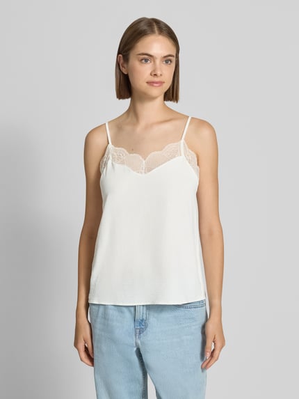 Frauenmodel trägt weißes Loose Fit Blusentop mit Spitzenbesatz Model 'TIFFANY' von PIECES, dezente Textur, Ganzkörperansicht von vorne.