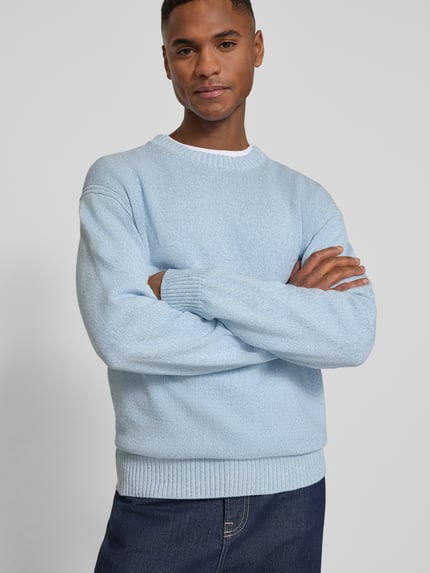 Mannelijk model draagt Regular Fit Pullover uit puur katoen model 'KERLINO' van BOSS Orange in melangelook, ronde hals, labelpatch, knitwear, lichtblauw, lange mouw, geribde boorden, materiaalverwerking: puur katoen, vooraanzicht bovenlichaam.