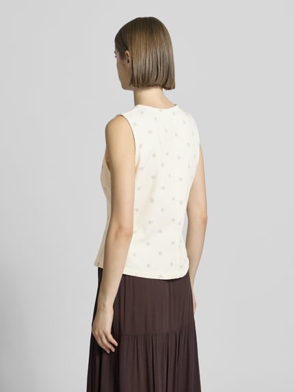 Vrouwenmodel draagt Regular Fit bodywarmer uit puur katoen model 'NAOMI' van Only, look: all-over bloemenmotief, twill materiaalverwerking, regular fit pasvorm, knoopsluiting, detailopname rugaanzicht.