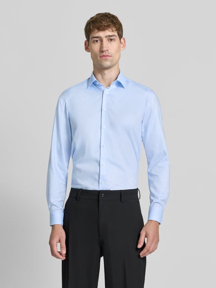 Männermodel trägt Super Slim Fit Businesshemd mit Kentkragen von OLYMP in Hellblau, unifarben, glatte Webware, Ganzkörperansicht von vorne.