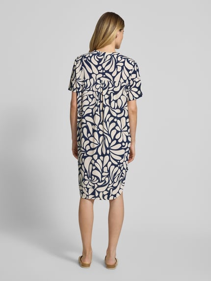 Männermodel trägt Knielanges Kleid mit V-Ausschnitt Modell 'Floy' von FREE/QUENT, straight fit, stretchiger Material-Mix, Muster in Dunkelblau und Beige, knielang, Ganzkörperansicht Rückansicht.