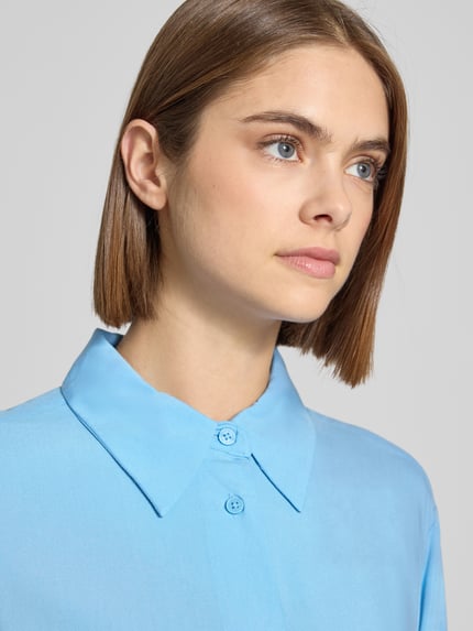 Vrouwenmodel draagt Regular Fit Hemdbluse aus reiner Viskose van Marc O'Polo Denim, unifarben, lange mouwen, close-up bovenlichaam.