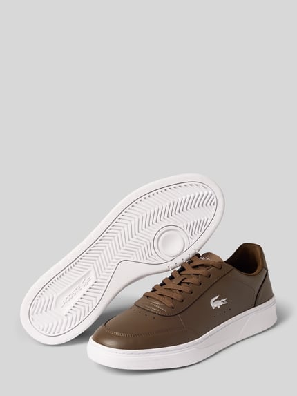 Produktfoto, brązowe sneakersy o gładkiej fakturze z białą podeszwą, wytłoczone logo, model 'Court Pro' od Lacoste, sneakersy męskie
