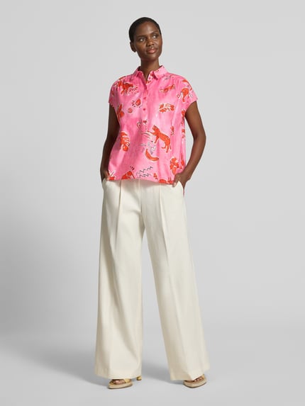Frauenmodel trägt Regular Fit Bluse im Allover-Look von Milano Italy aus Reiner Baumwolle, Hemdblusenkragen, Knopfleiste, rosa-rot gemustert, kombiniert mit weiter cremefarbener Hose, Rückenlänge bei Größe 36: 58 cm, Ärmellänge bei Größe 36: 4 cm, Ganzkörperansicht von vorne.
