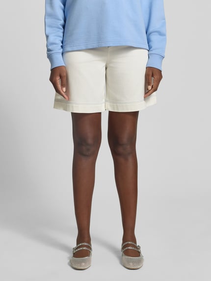 Frauenmodel trägt Jeansshorts mit Eingrifftaschen von Marc Cain in Offwhite, Regular Fit aus Baumwoll-Elasthan-Mix, Ganzkörperansicht von vorne.