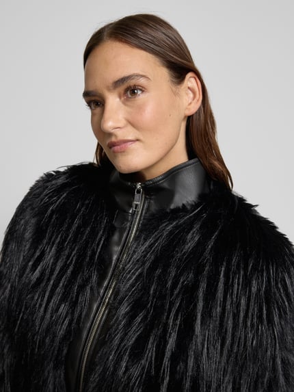 Frauenmodel trägt Slim Fit Jacke in Kunstfell-Optik Modell 'CECOOL' von BOSS, unifarben schwarz, Stehkragen, Zweiwege-Reißverschluss, Nahaufnahme Oberkörper.