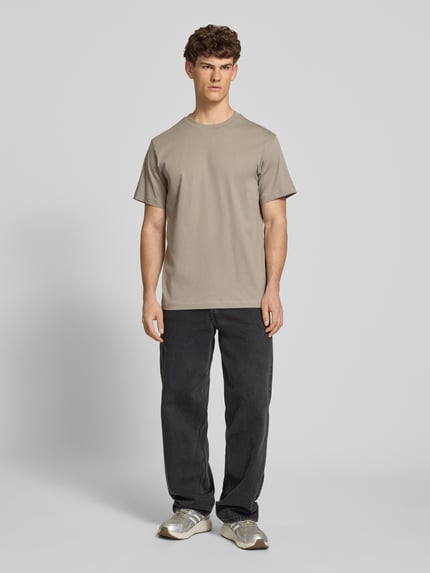 Männermodel trägt T-Shirt aus Baumwolle mit Rundhalsausschnitt von G-Star Raw, sandfarben, Regular Fit, glatte Textur, Ganzkörperansicht von vorne.