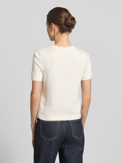 Frauenmodel trägt Strickshirt mit Rundhalsausschnitt mit Wellensaum von Zero in Creme, Körpernaher-Schnitt, 1/2-Arm, Ganzkörperansicht Rückansicht. Rückenlänge bei Größe 36: 50 cm, Ärmellänge bei Größe 36: 20 cm.