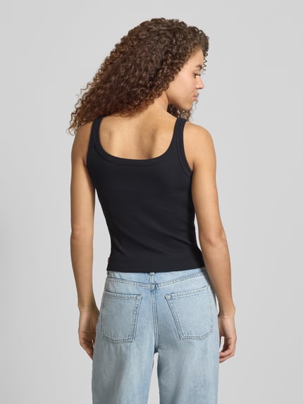 Vrouwenmodel draagt Slim Fit Top aus Baumwoll-Mix Modell 'ESSENTIAL RIBBED TANK' van Levi's®, zwart uni, label patch, fijnrib, u-hals, Ganzkörperansicht achteraan.
