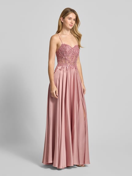Frauenmodel trägt Abendkleid mit Zierstein- und Paillettenbesatz von Mascara aus rosafarbenem Satin, taillierte Passform, Herz-Ausschnitt, floraler Spitzenbesatz, ärmelloses Design mit Spaghettiträgern, Maxilänge, Nahtreißverschluss, Ganzkörperansicht von vorne.