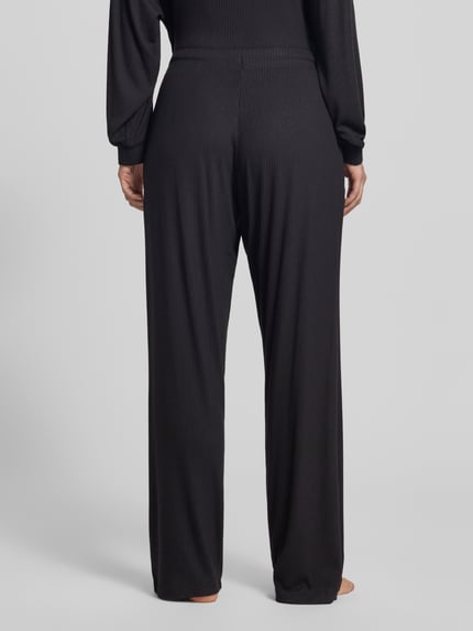 Frauenmodel trägt Relaxed Fit Sweathose aus Modal-Mix Modell 'HUGO HEART' von HUGO, Damen Sweathose, schwarz, gerippte Textur, Ganzkörperansicht Rückansicht
